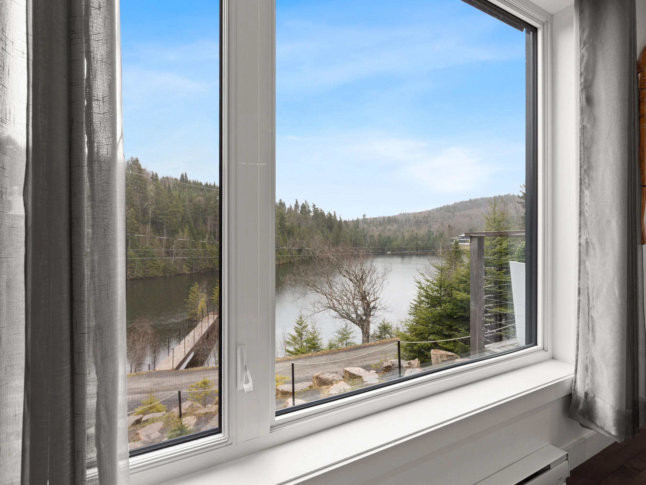 Vue sur le lac et la montagne depuis une fenêtre du chalet Le Céleste